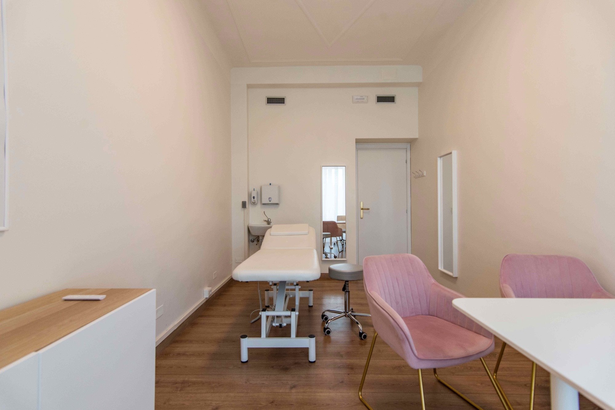 Vista longitudinale con lettino e area colloquio in studio professionale Exclusive presso Spatium Policlinico, Milano