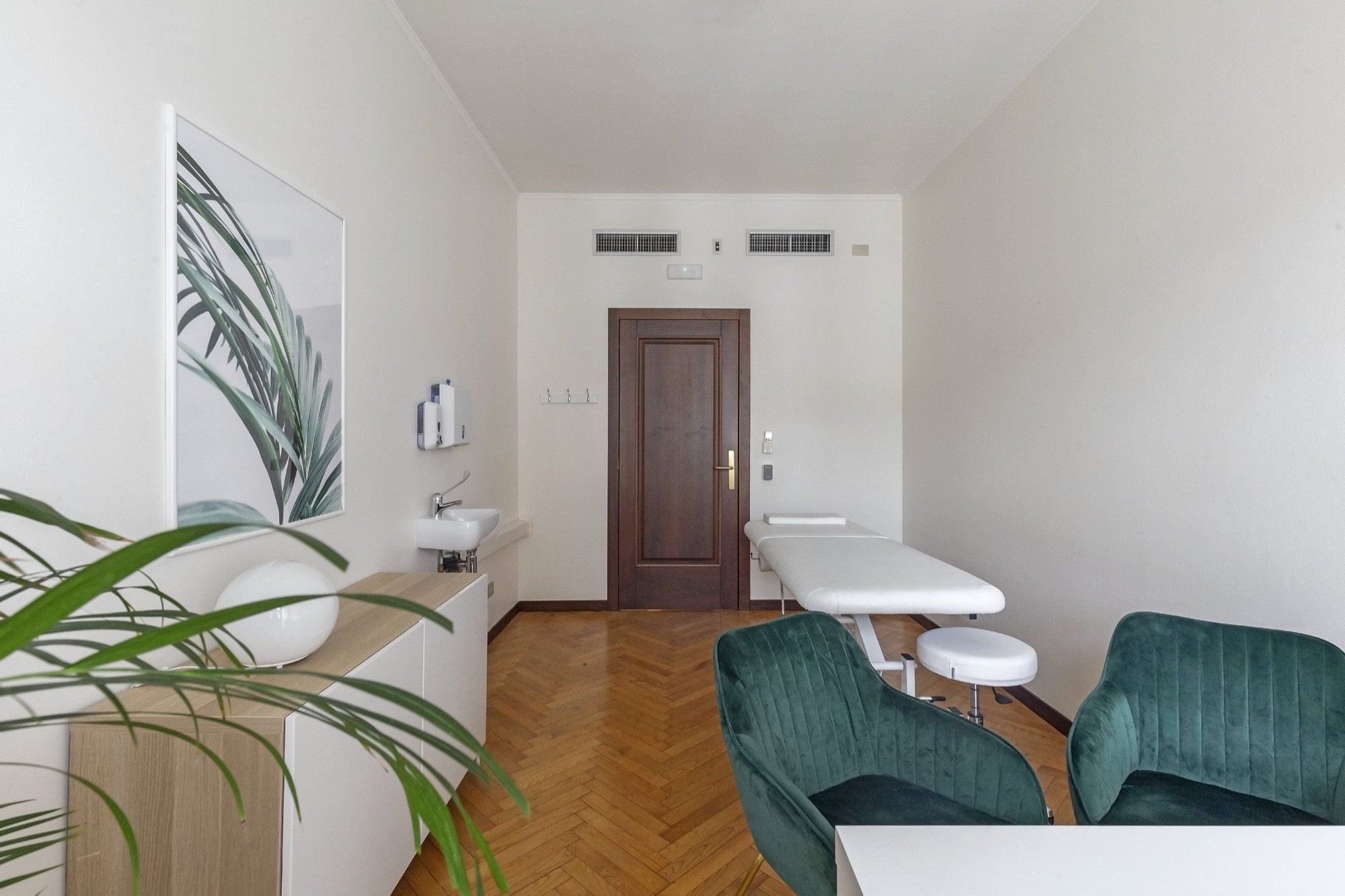 Vista longitudinale con lettino e poltroncine verdi in studio professionale Exclusive presso Spatium Duomo, Milano