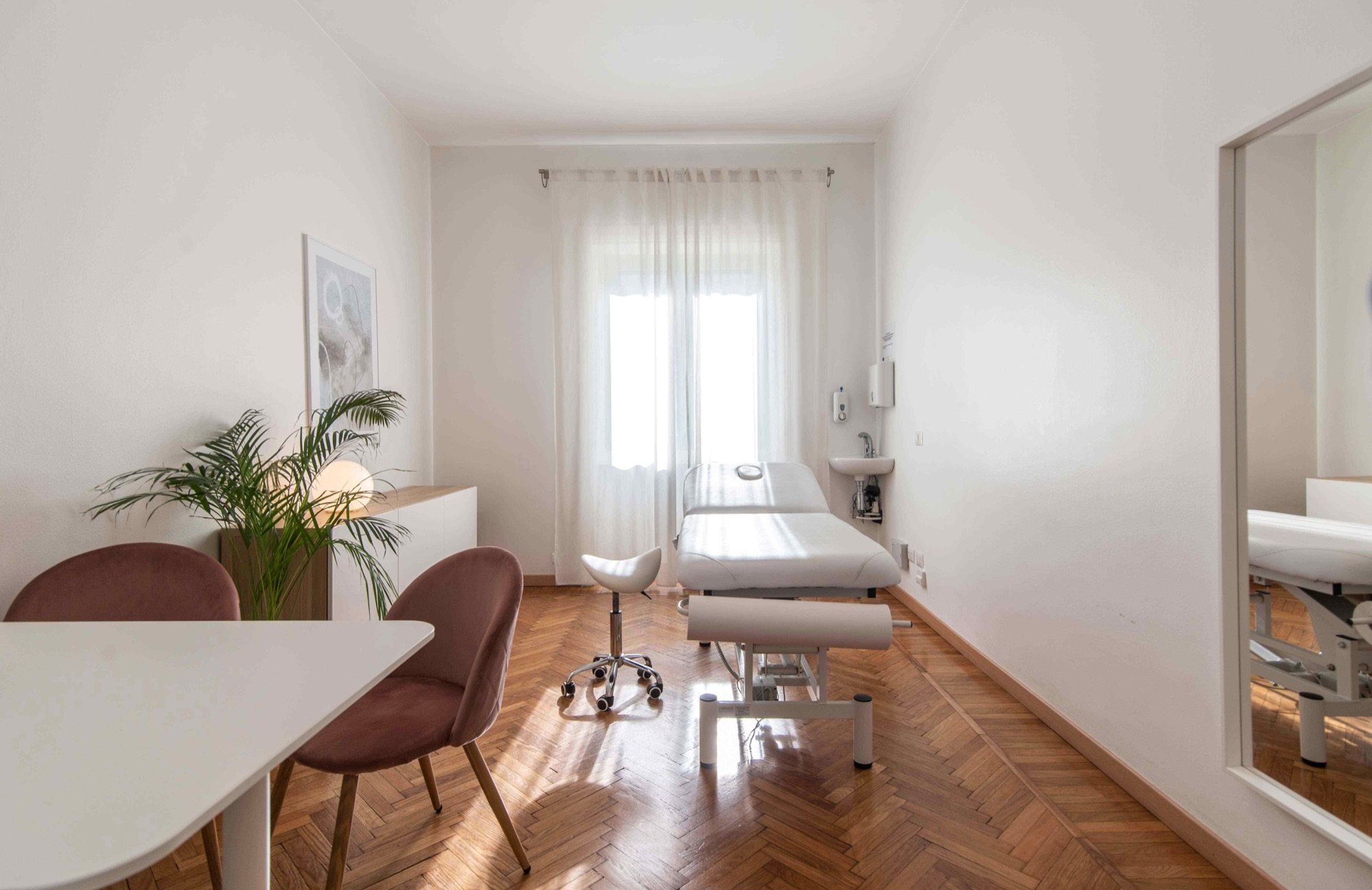Vista longitudinale con tavolo colloquio e lettino in studio professionale Exclusive presso Spatium Loreto, Milano