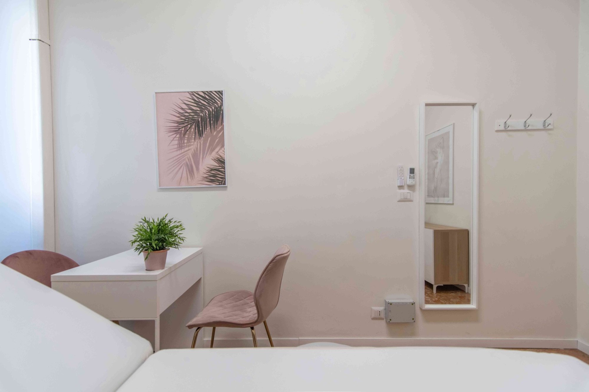 Scrivania con poltroncina rosa, specchio e lettino parziale in studio professionale Premium presso Spatium Repubblica, Milano