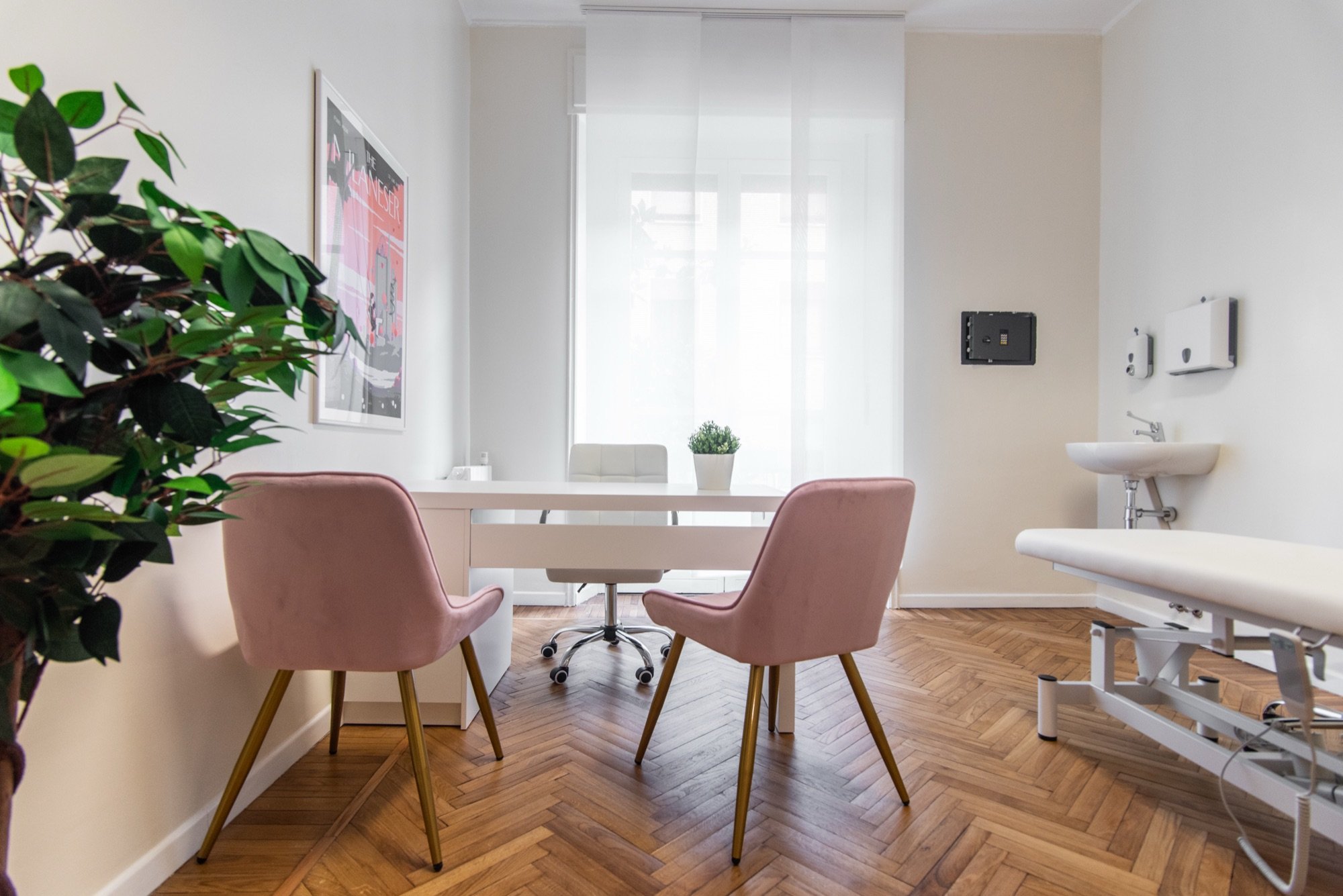 Tavolo colloquio con due poltroncine rosa e pianta in studio professionale Exclusive presso Spatium Santa Sofia, Milano