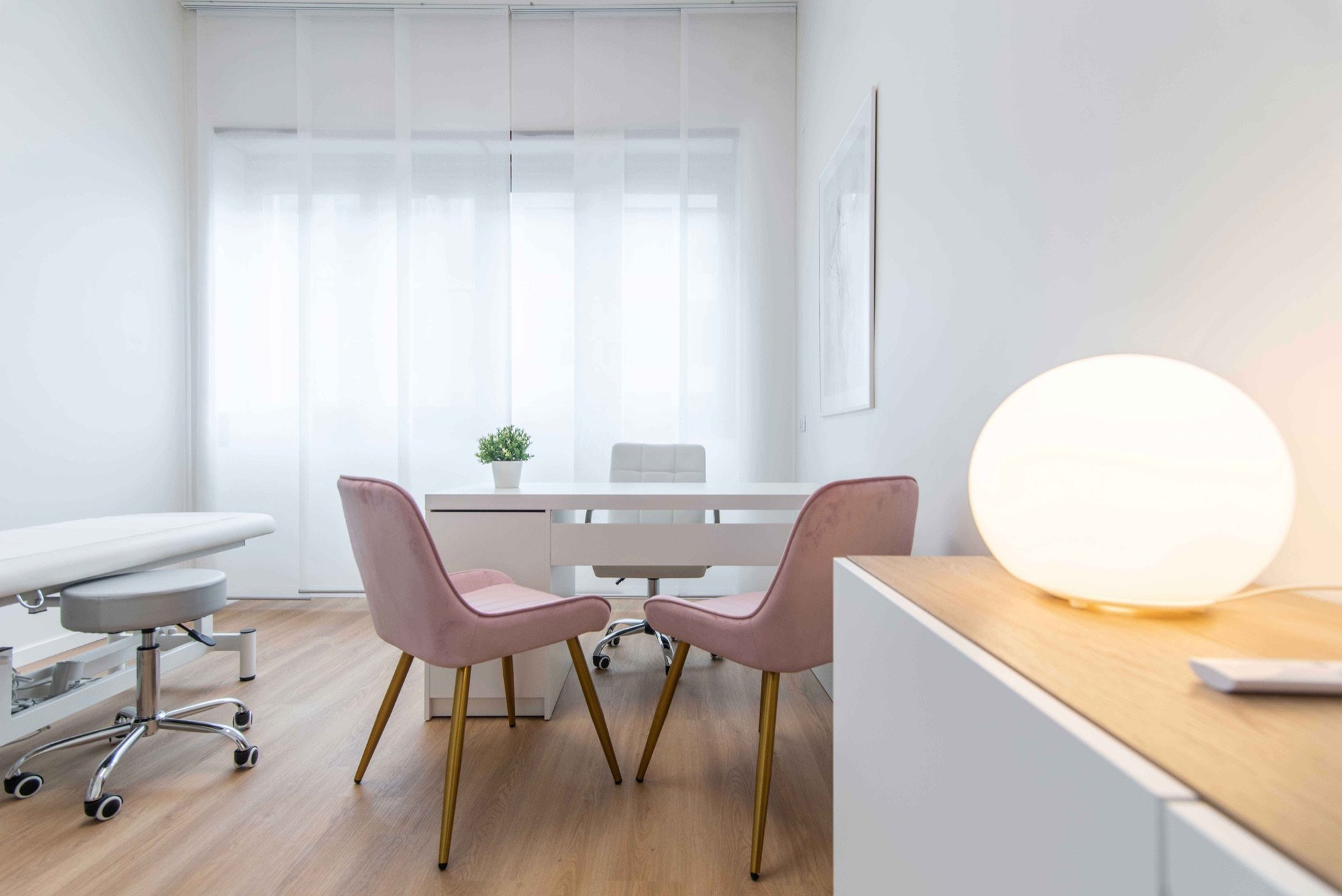Tavolo colloquio con poltroncine rosa e lampada in primo piano in studio professionale Top presso Spatium Vittor Pisani, Milano