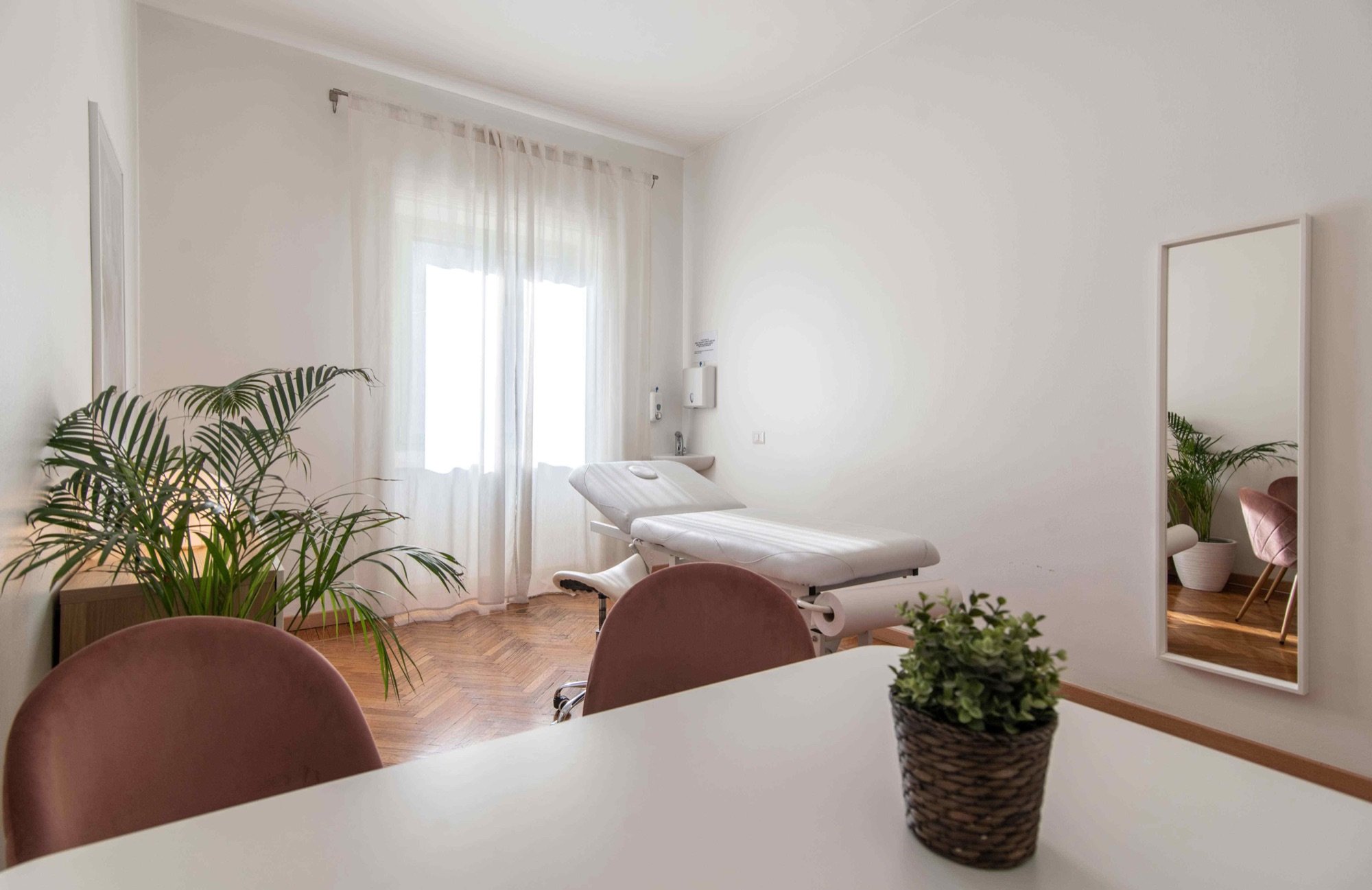 Tavolo colloquio con sedute e lettino vicino alla finestra in studio professionale Exclusive presso Spatium Loreto, Milano