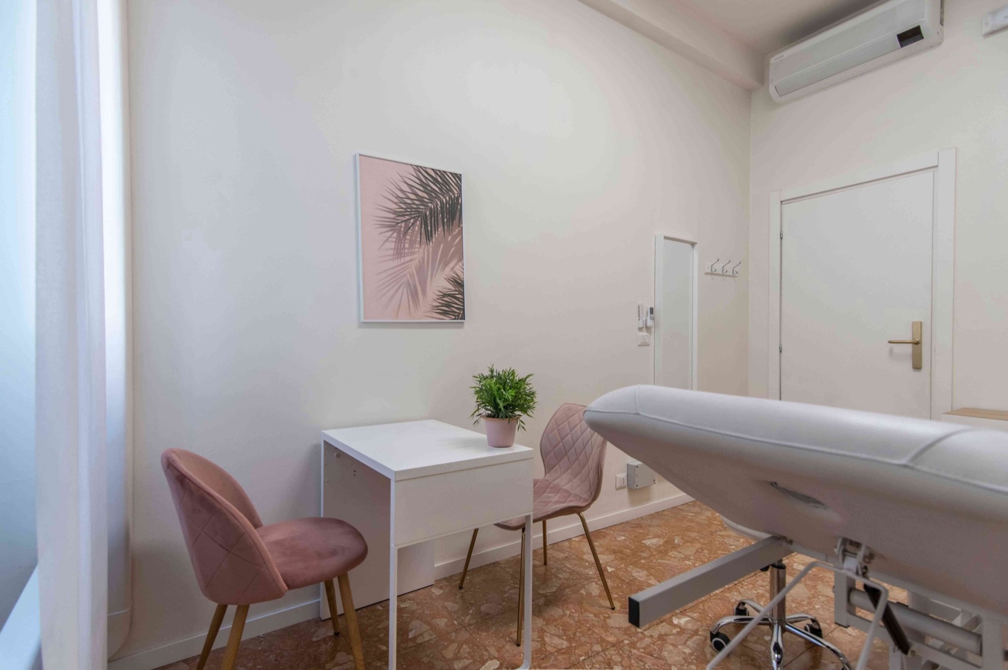 Tavolo colloquio con sedute rosa e lettino in primo piano in studio professionale Premium presso Spatium Repubblica, Milano